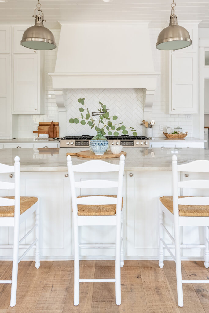 a view of a white farmhouse kitchen with island and barstools
