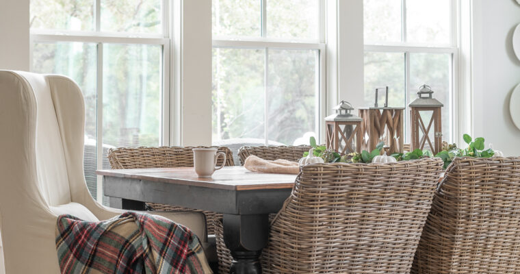 plaid fall blanks hangs over an upholstered dining chair at a farmhouse table
