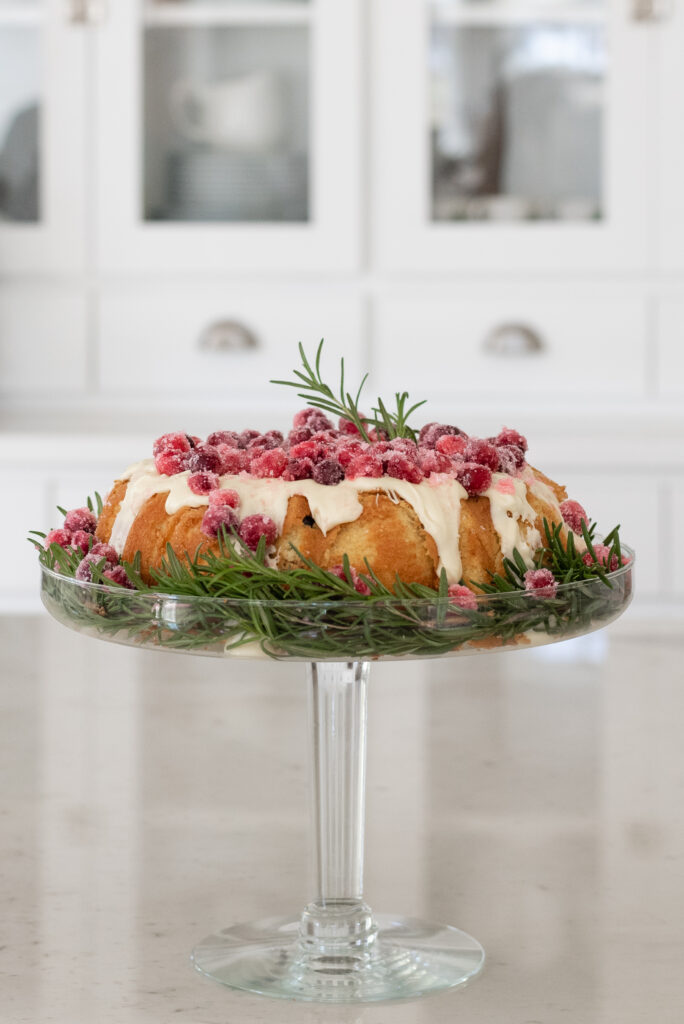 A beautiful cranberry orange bundt cake topped with sugered cranberries and white chocolate