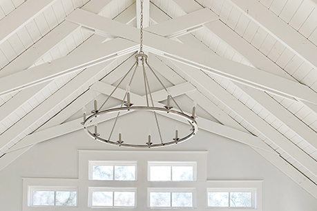 a wagon wheel light fixture in a vaulted living room