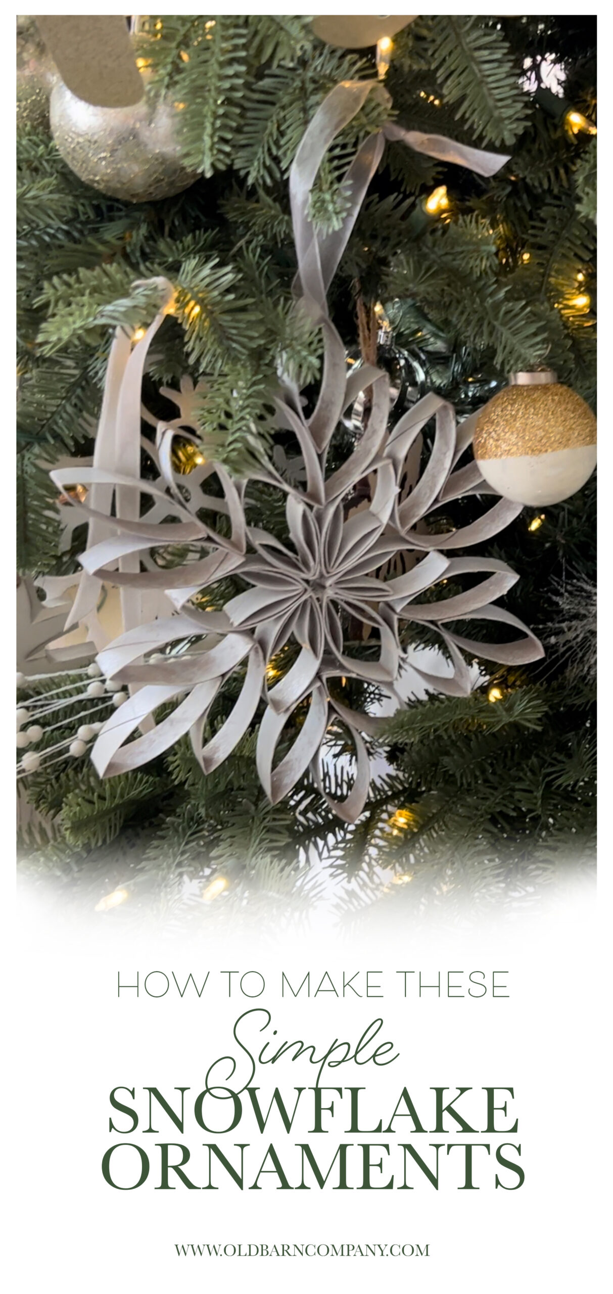 a large snowflake ornament hanging from a ribbon on a Christmas tree. The snowflake is made up cut up toilet paper rolls.