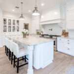 A kitchen island, hutch, and countertop with white cabinets.